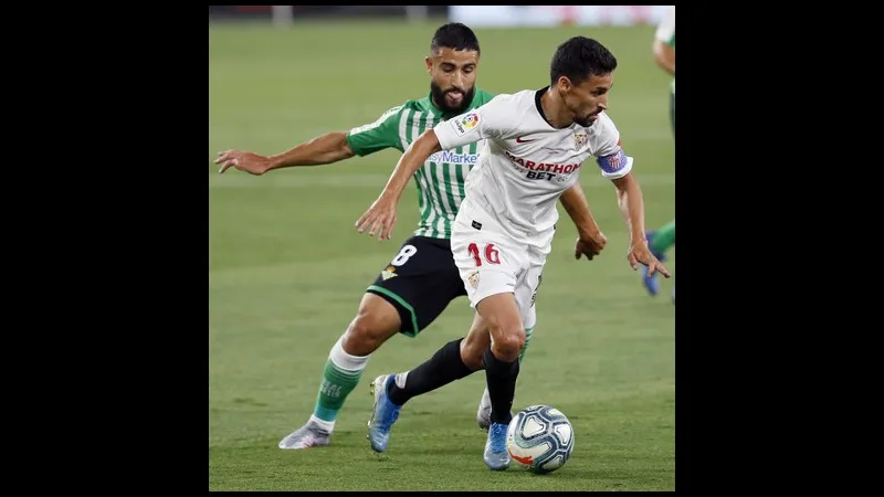 Cầu thủ của Sevilla đi bóng qua hậu vệ của Real Betis trong trận đấu